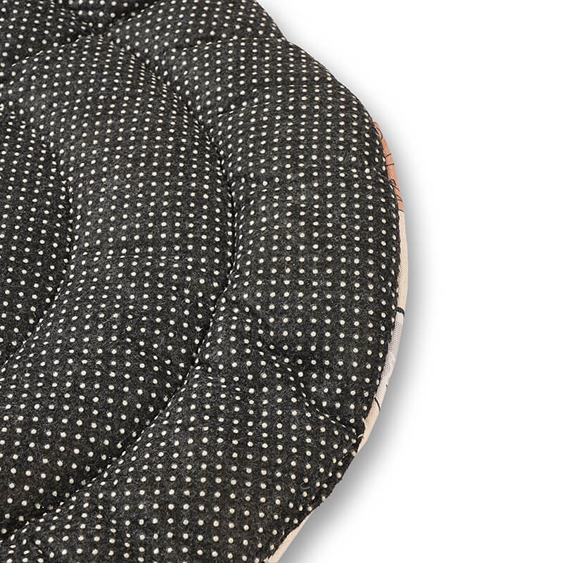 Close-up of the Dog Daze pet mat’s anti-skid bottom showing a black fabric surface with white grip dots and quilted stitching for stability on floors.