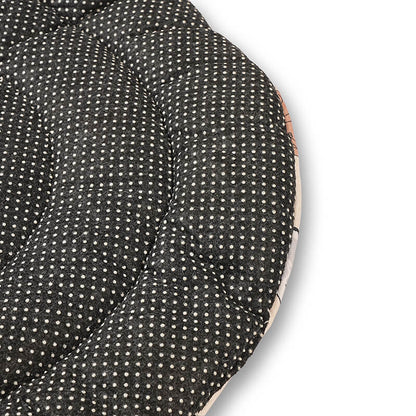 Close-up of the Dog Daze pet mat’s anti-skid bottom showing a black fabric surface with white grip dots and quilted stitching for stability on floors.